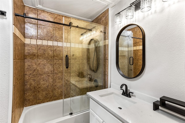 full bathroom with a textured wall, vanity, and bath / shower combo with glass door