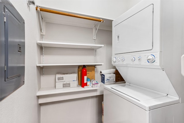 laundry area with stacked washing maching and dryer, electric panel, and laundry area