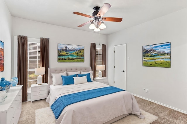 bedroom with a ceiling fan, light colored carpet, and baseboards