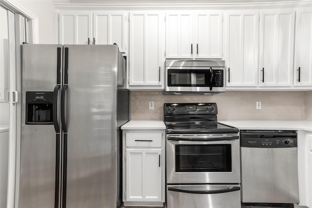 kitchen featuring stainless steel appliances, light countertops, decorative backsplash, and white cabinetry