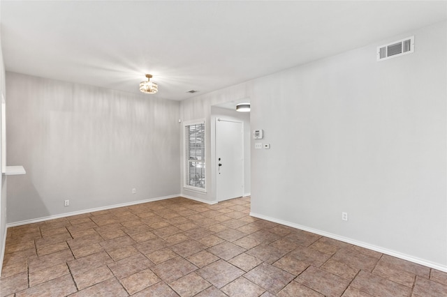 unfurnished room with visible vents and baseboards