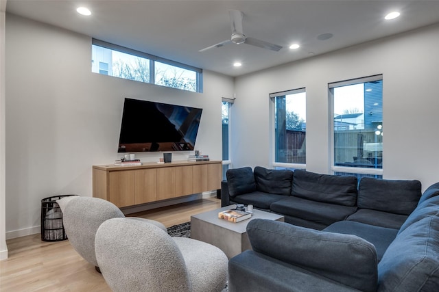 living room featuring light wood-type flooring, ceiling fan, baseboards, and recessed lighting