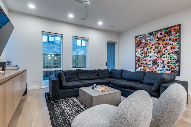 living room with light wood-style floors, recessed lighting, and baseboards