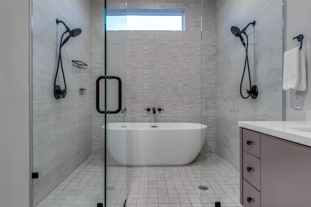 bathroom with a stall shower, a freestanding bath, and vanity