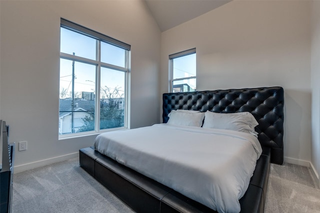 bedroom with lofted ceiling, baseboards, and light colored carpet