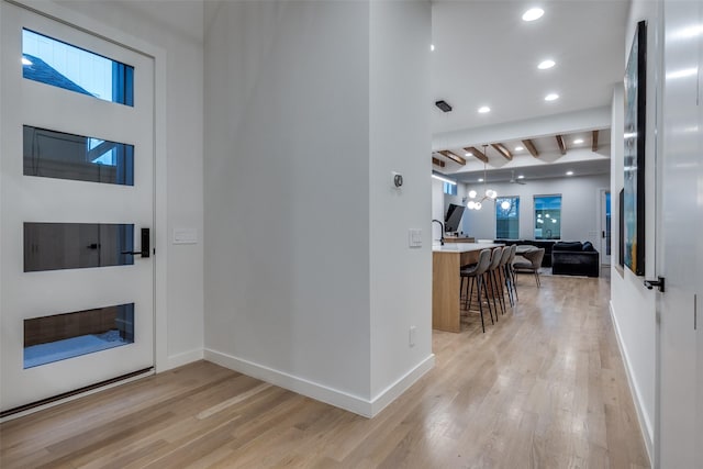 foyer featuring light wood finished floors, baseboards, and recessed lighting