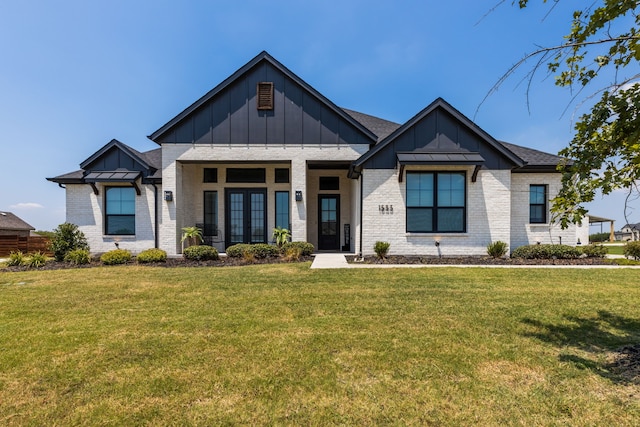 modern inspired farmhouse featuring board and batten siding, french doors, brick siding, and a front lawn