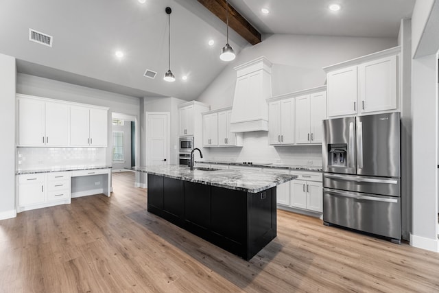 kitchen featuring built in desk, stainless steel appliances, visible vents, a sink, and light stone countertops