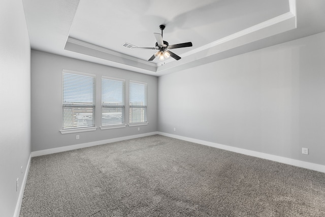 unfurnished room with carpet, crown molding, a raised ceiling, ceiling fan, and baseboards