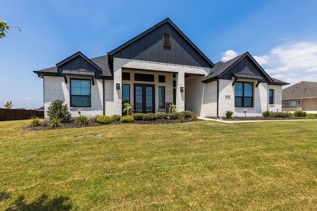 modern inspired farmhouse with french doors, brick siding, a shingled roof, board and batten siding, and a front lawn