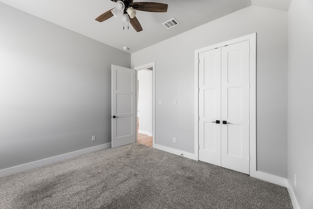 unfurnished bedroom featuring visible vents, baseboards, carpet, vaulted ceiling, and a closet