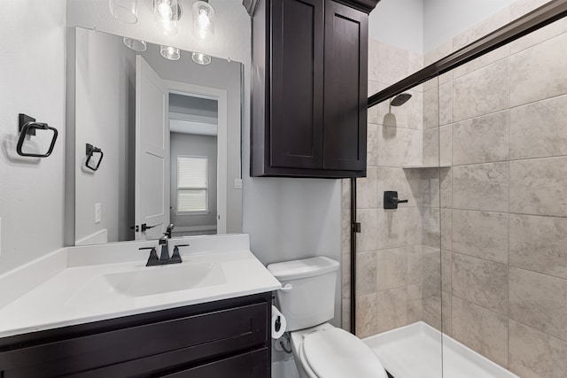 full bathroom featuring toilet, a shower stall, and vanity