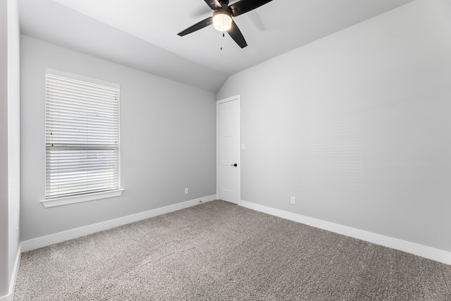 carpeted spare room with ceiling fan, baseboards, and vaulted ceiling