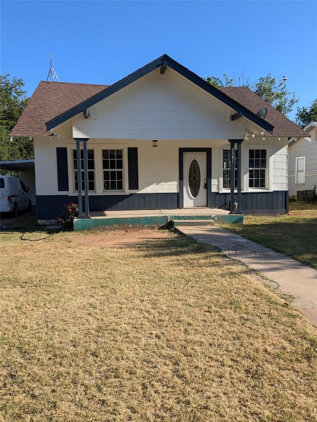 view of front of home with a front lawn and roof with shingles