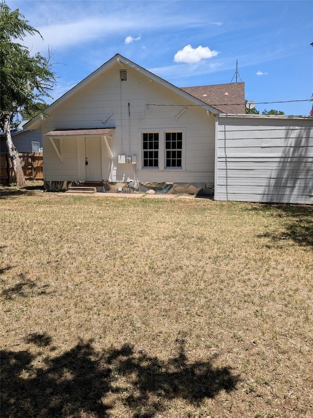 rear view of property with a lawn