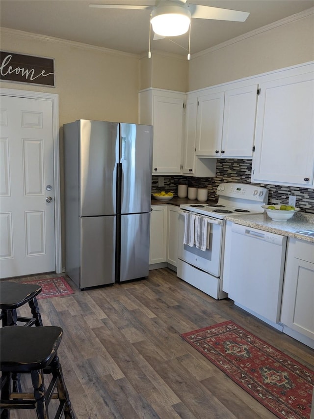 kitchen featuring white appliances, dark wood-style floors, ornamental molding, and white cabinets