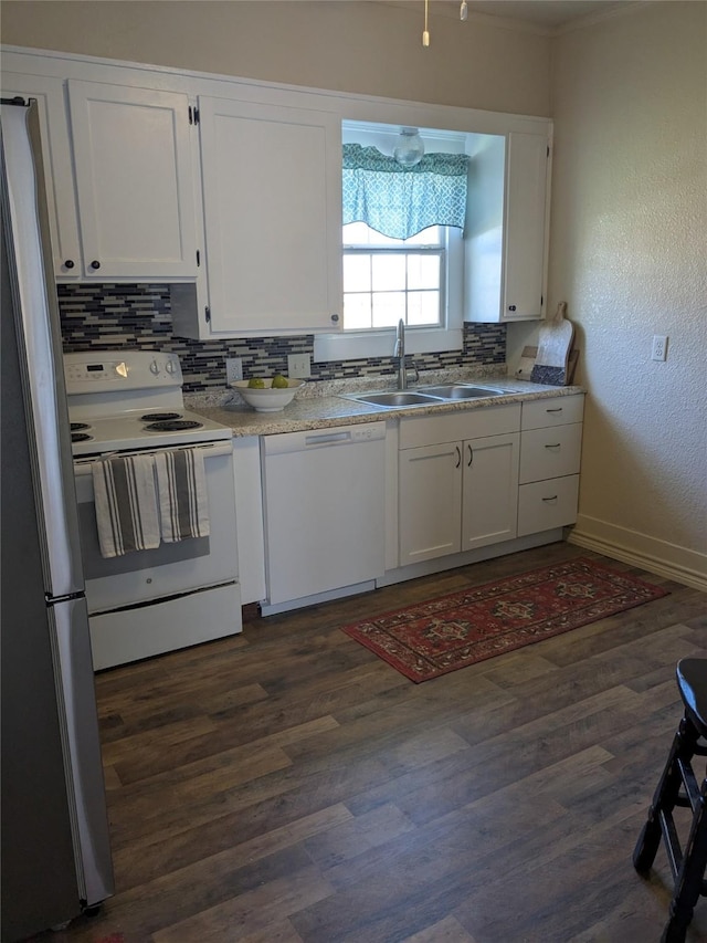 kitchen featuring dark wood-type flooring, white appliances, a sink, white cabinetry, and backsplash