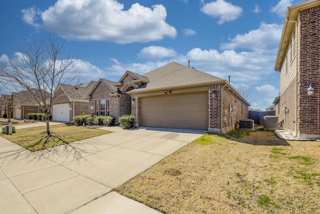 view of front facade with concrete driveway, an attached garage, cooling unit, a front lawn, and brick siding