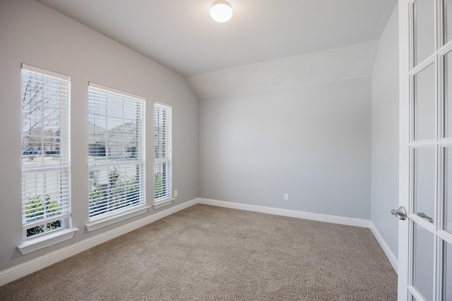 unfurnished room with lofted ceiling, carpet flooring, and baseboards