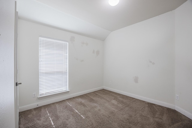 spare room with lofted ceiling, carpet flooring, and baseboards