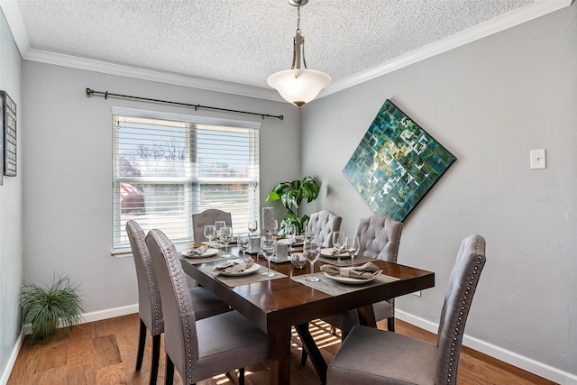 dining space featuring ornamental molding, a textured ceiling, baseboards, and wood finished floors