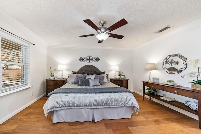 bedroom featuring visible vents, crown molding, and light wood-style flooring