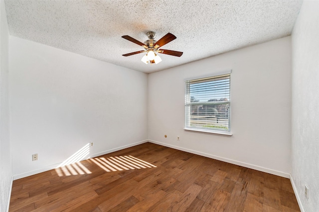 unfurnished room with a textured ceiling, ceiling fan, hardwood / wood-style flooring, and baseboards