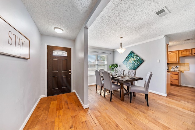 foyer featuring baseboards, visible vents, and light wood-style floors