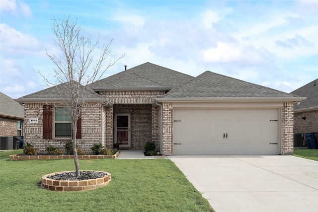 single story home featuring driveway, an attached garage, a shingled roof, and a front yard