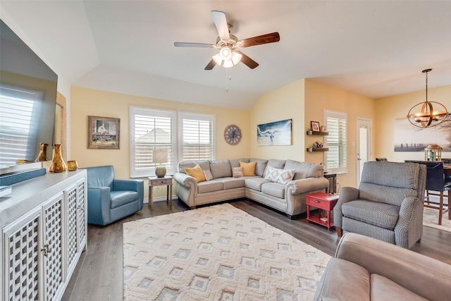 living room with ceiling fan with notable chandelier, dark wood-type flooring, and lofted ceiling