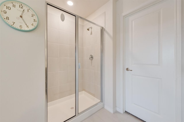 bathroom with a stall shower and tile patterned flooring