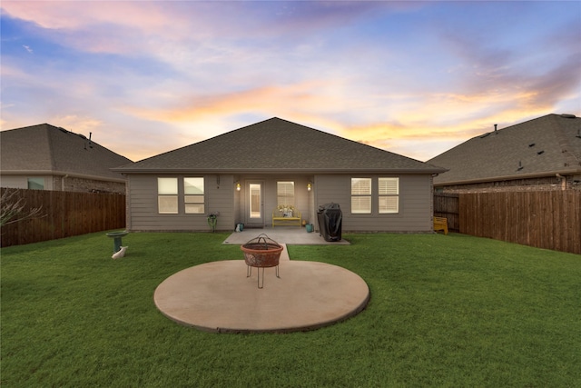 back of house featuring a patio, an outdoor fire pit, a lawn, and a fenced backyard