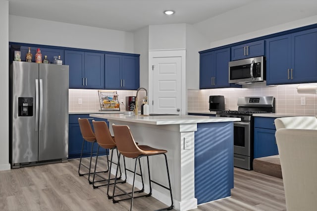 kitchen with blue cabinets, appliances with stainless steel finishes, and light countertops