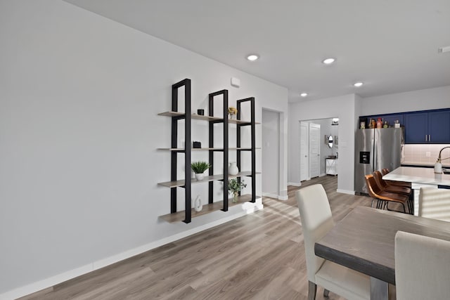 dining space featuring light wood finished floors, baseboards, and recessed lighting