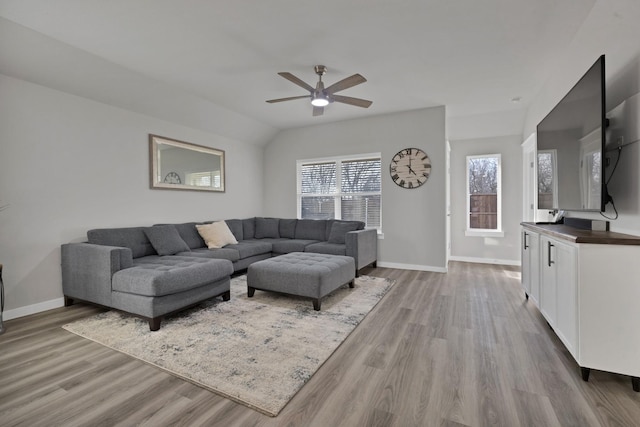 living room featuring a ceiling fan, lofted ceiling, baseboards, and wood finished floors