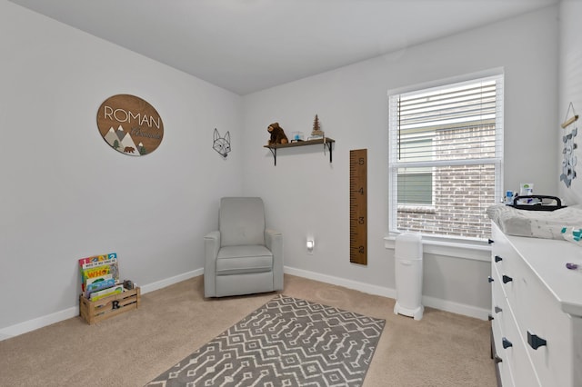 sitting room with baseboards and light colored carpet