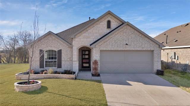 french country inspired facade with a garage, brick siding, a shingled roof, concrete driveway, and a front lawn