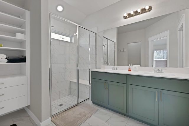 full bathroom with double vanity, marble finish floor, a shower stall, and a sink