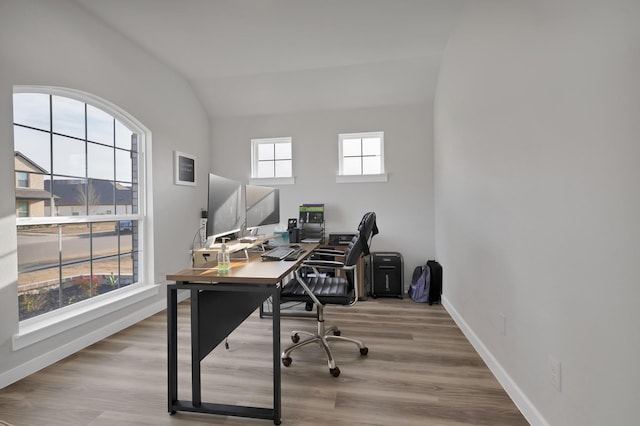 office featuring lofted ceiling, baseboards, and wood finished floors