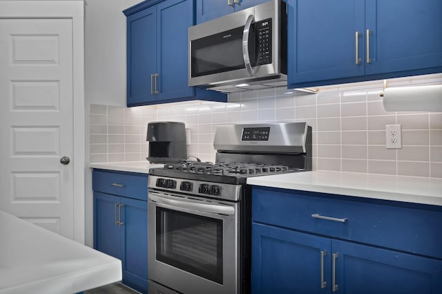 kitchen featuring light countertops, appliances with stainless steel finishes, decorative backsplash, and blue cabinets