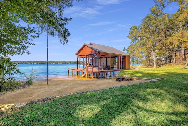 view of dock with a water view and a lawn