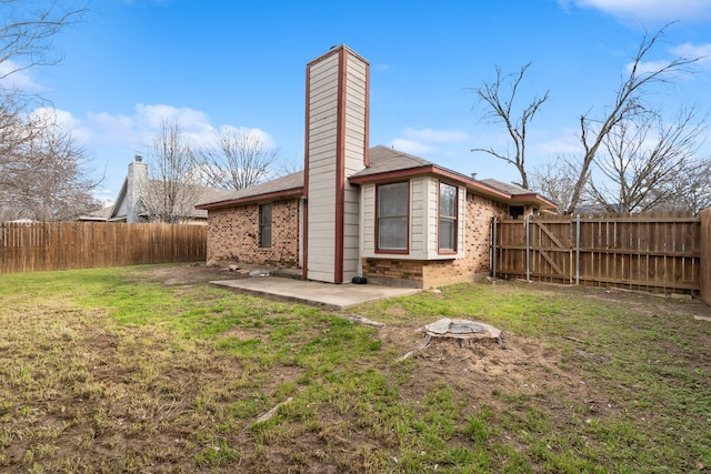 2901 Anysa Ln, Denton, TX 76209 - back of house featuring a fenced backyard, brick siding, a patio, and a chimney