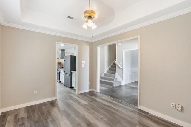1542 Glenmore Dr, Lewisville, TX 75077 - spare room with a raised ceiling, a ceiling fan, wood finished floors, stairs, and crown molding