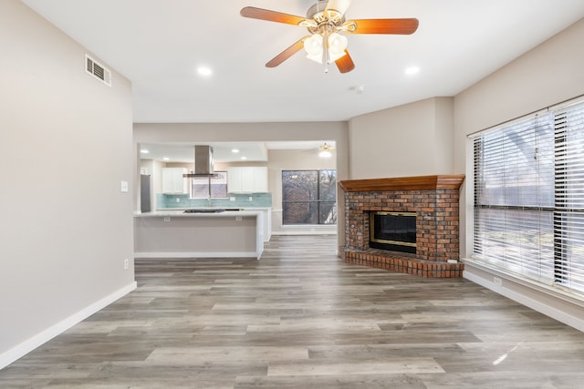 1542 Glenmore Dr, Lewisville, TX 75077 - unfurnished living room featuring a ceiling fan, baseboards, light wood-style flooring, plenty of natural light, and recessed lighting