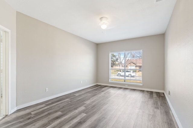 empty room featuring wood finished floors and baseboards