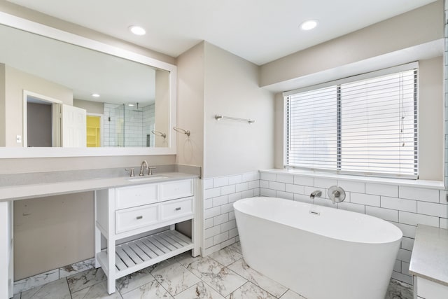 1542 Glenmore Dr, Lewisville, TX 75077 - full bath featuring marble look tiles, a freestanding tub, vanity, recessed lighting, and a wainscoted wall