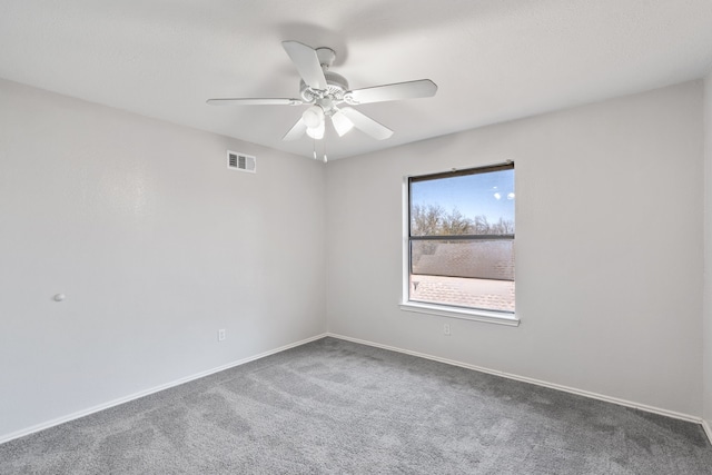 carpeted empty room featuring baseboards, visible vents, and ceiling fan