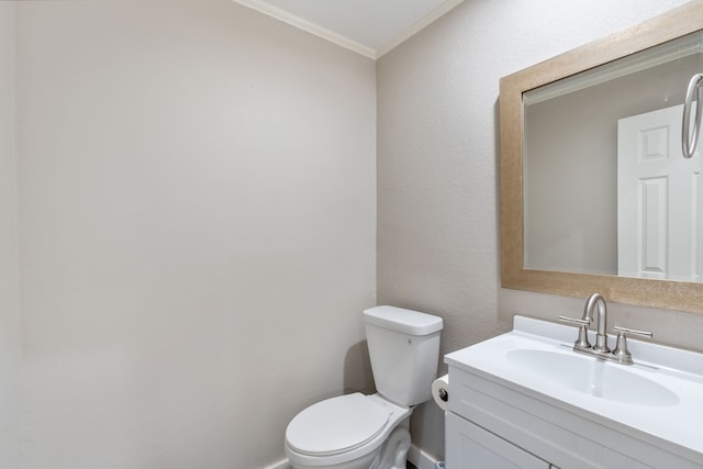 half bathroom featuring vanity, toilet, and ornamental molding