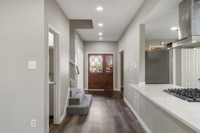 foyer featuring recessed lighting, baseboards, dark wood-type flooring, and stairs