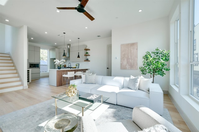 living area with stairway, light wood-style flooring, and recessed lighting